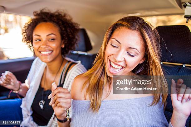 Women dancing together in car