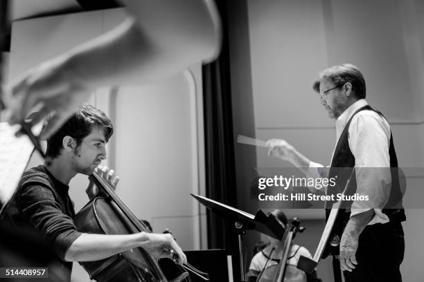 professor conducting college orchestra - dirigent stock-fotos und bilder