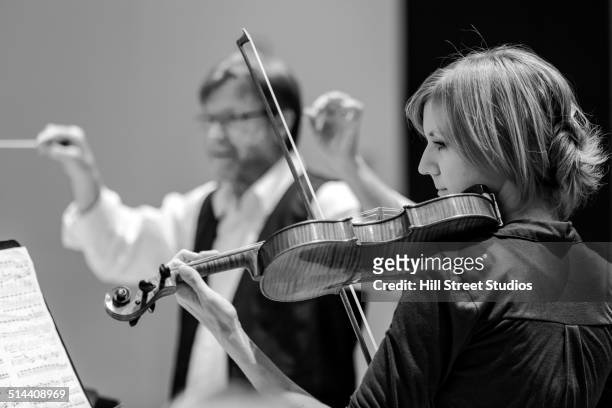 student playing violin in college orchestra - orchestra conductor foto e immagini stock