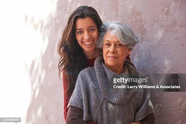 older hispanic woman and granddaughter smiling - young woman with grandmother stockfoto's en -beelden