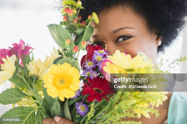 african american woman holding bouquet of flowers - arrangements of flowers stock pictures, royalty-free photos & images