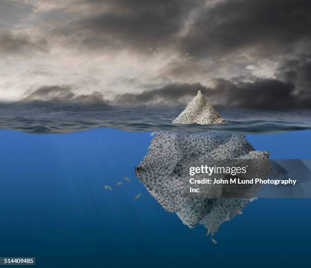 iceberg of money floating in stormy ocean - hiding money stock pictures, royalty-free photos & images