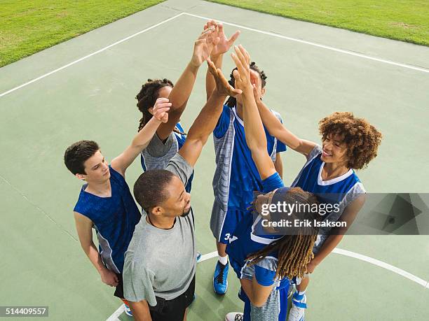 basketball team high fiving on court - basketball team work stock pictures, royalty-free photos & images