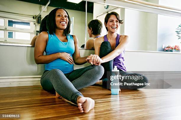 women holding hands in yoga studio - prenatal yoga stock pictures, royalty-free photos & images