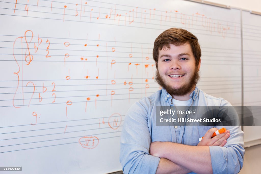 Caucasian student standing at board in music class