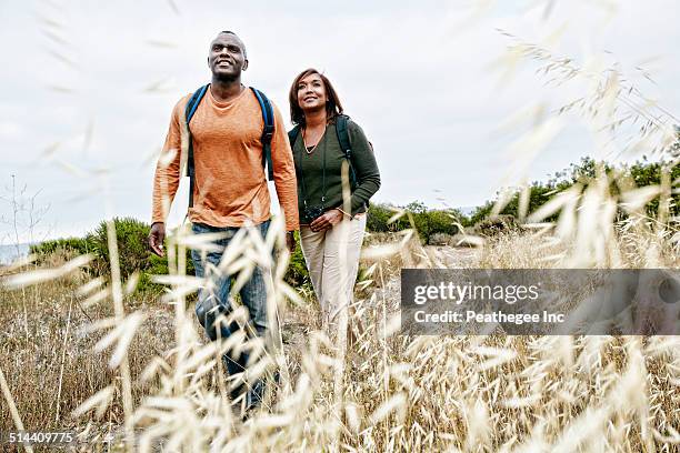 black couple hiking on rural hillside - couple travel middle age ストックフォトと画像