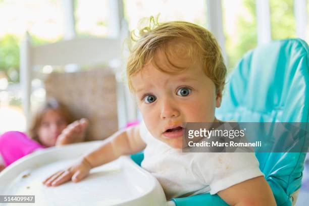 caucasian boy sitting in high chair - angry babies stock pictures, royalty-free photos & images