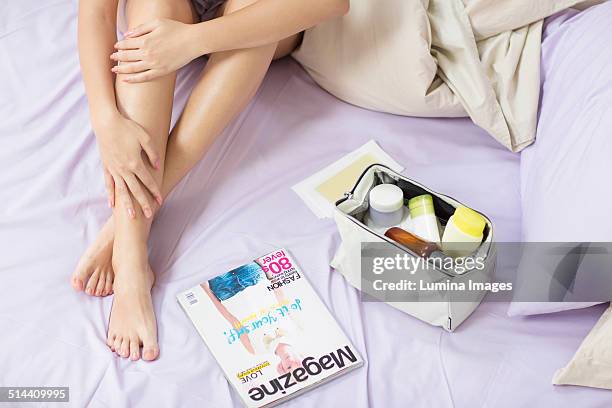 caucasian woman applying moisturizer to leg - magazine spread stock pictures, royalty-free photos & images