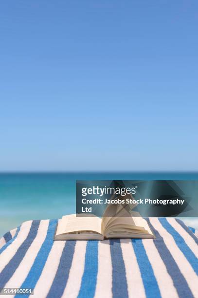 close up of book on deck chair on beach - deck chair 個照片及圖片檔