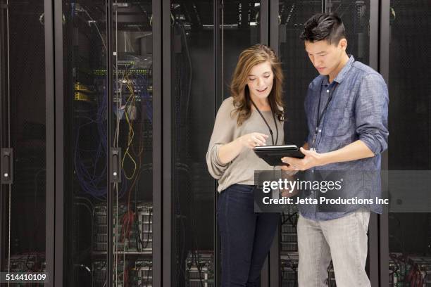 business people using tablet computer in server room - cyber security stock-fotos und bilder