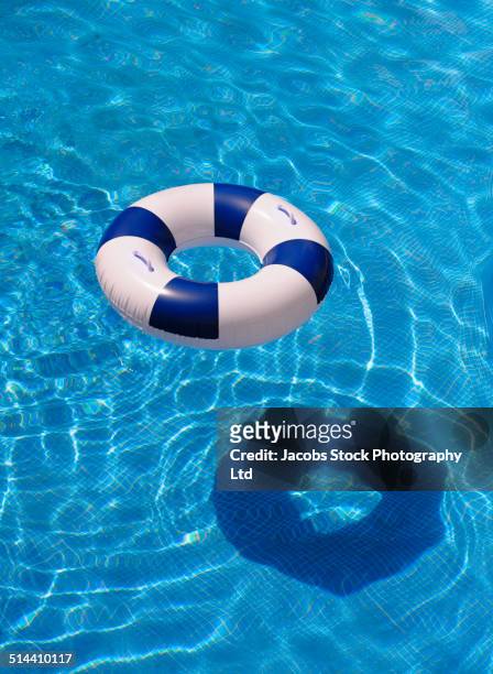inflatable ring casting shadow in swimming pool - inflatable ring stock-fotos und bilder