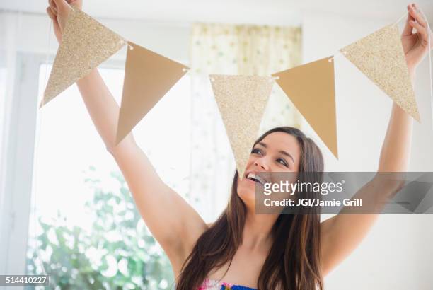 woman holding bunting flags in living room - grill party stockfoto's en -beelden