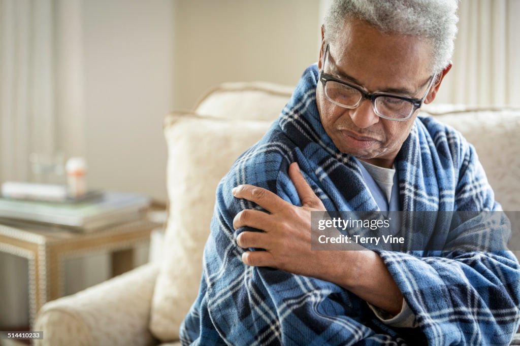 Senior African American man rubbing his shoulder