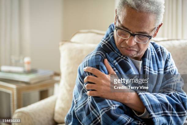 senior african american man rubbing his shoulder - man touching shoulder imagens e fotografias de stock