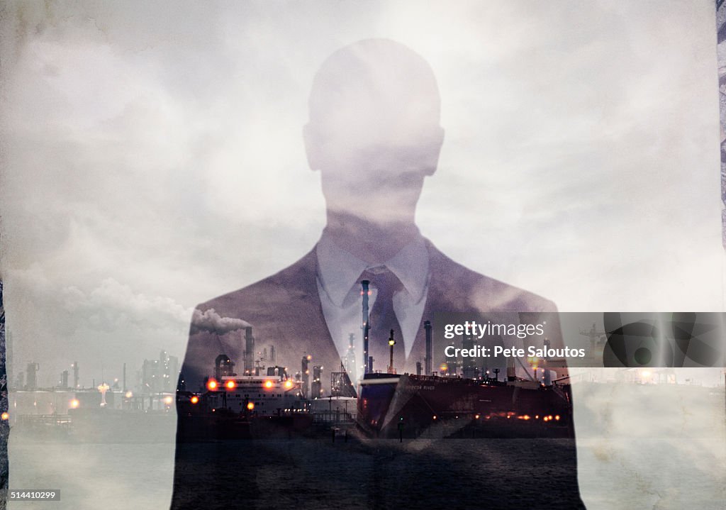 Double exposure of businessman and power plant