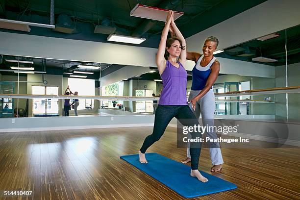 woman working with yoga teacher in studio - yoga studio - fotografias e filmes do acervo