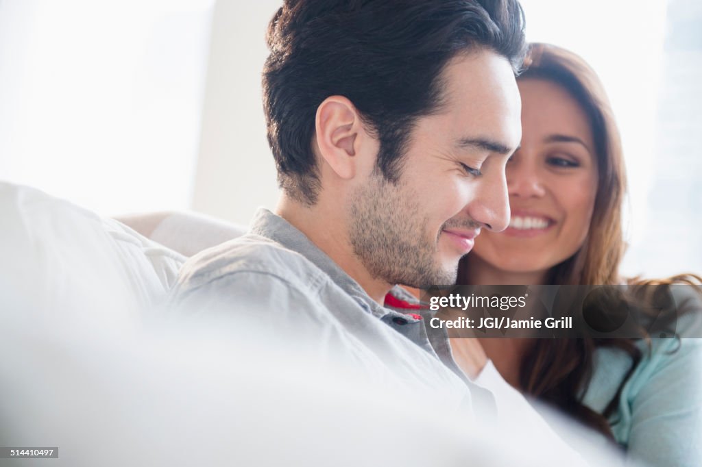 Couple smiling together on sofa