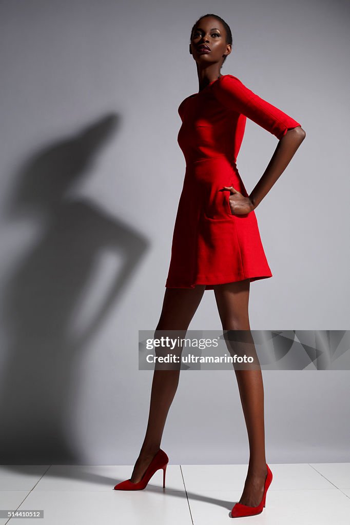 Moda bella di discendenza africana Giovane donna che indossa un abito rosso