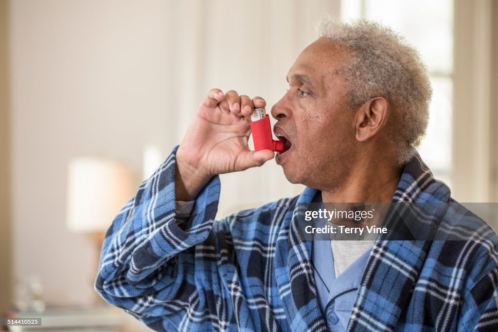 Senior African American man using inhaler