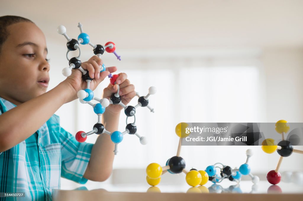 Mixed race boy playing with molecular models