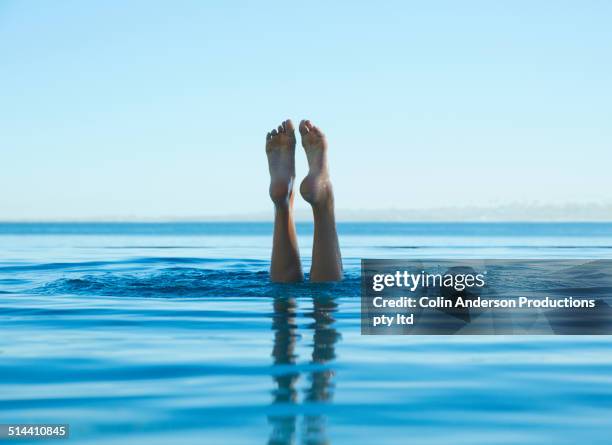 feet of caucasian girl swimming in tropical ocean - fare la verticale sulle mani foto e immagini stock