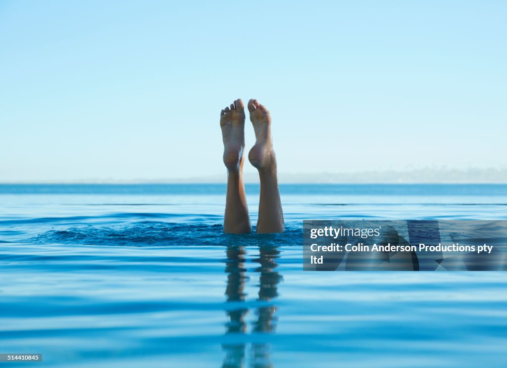 Feet of caucasian girl swimming in tropical ocean