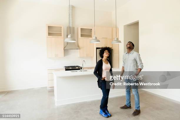 couple standing in kitchen in new house - house inspection stock pictures, royalty-free photos & images