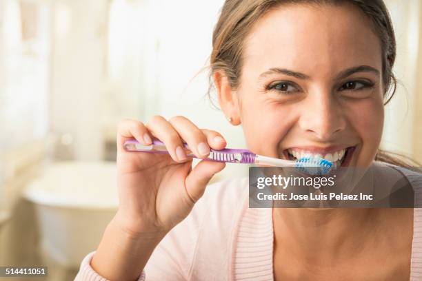 caucasian woman brushing her teeth - teeth cleaning stock pictures, royalty-free photos & images