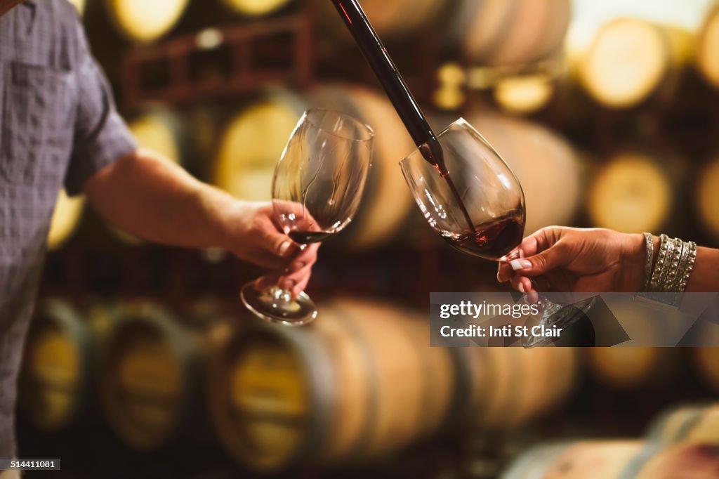 Caucasian couple tasting wine in cellar