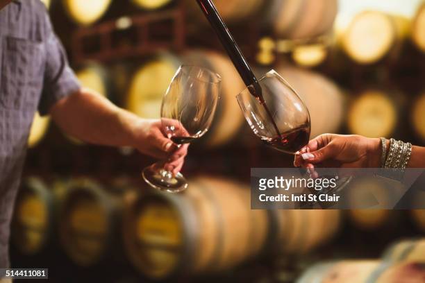 caucasian couple tasting wine in cellar - wine cellar stock pictures, royalty-free photos & images