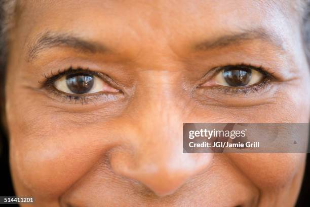 close up of mixed race woman smiling - focus noir photos et images de collection