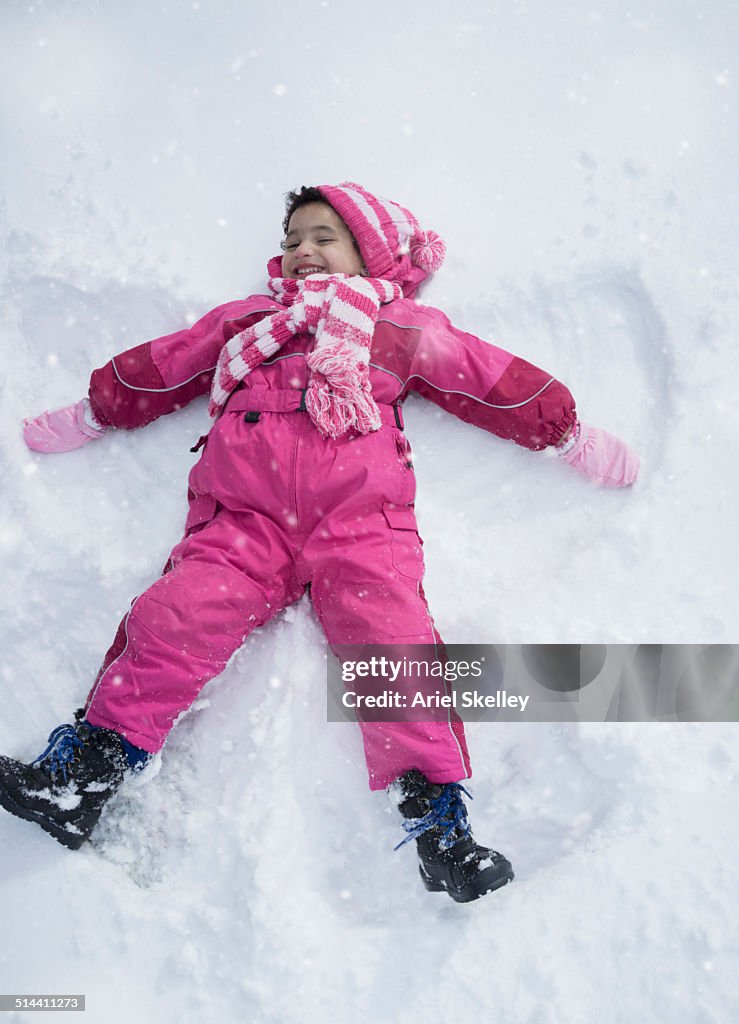 Girl making snow angel outdoors