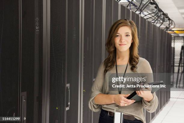 mixed race businesswoman using tablet computer in server room - good technology inc stock pictures, royalty-free photos & images