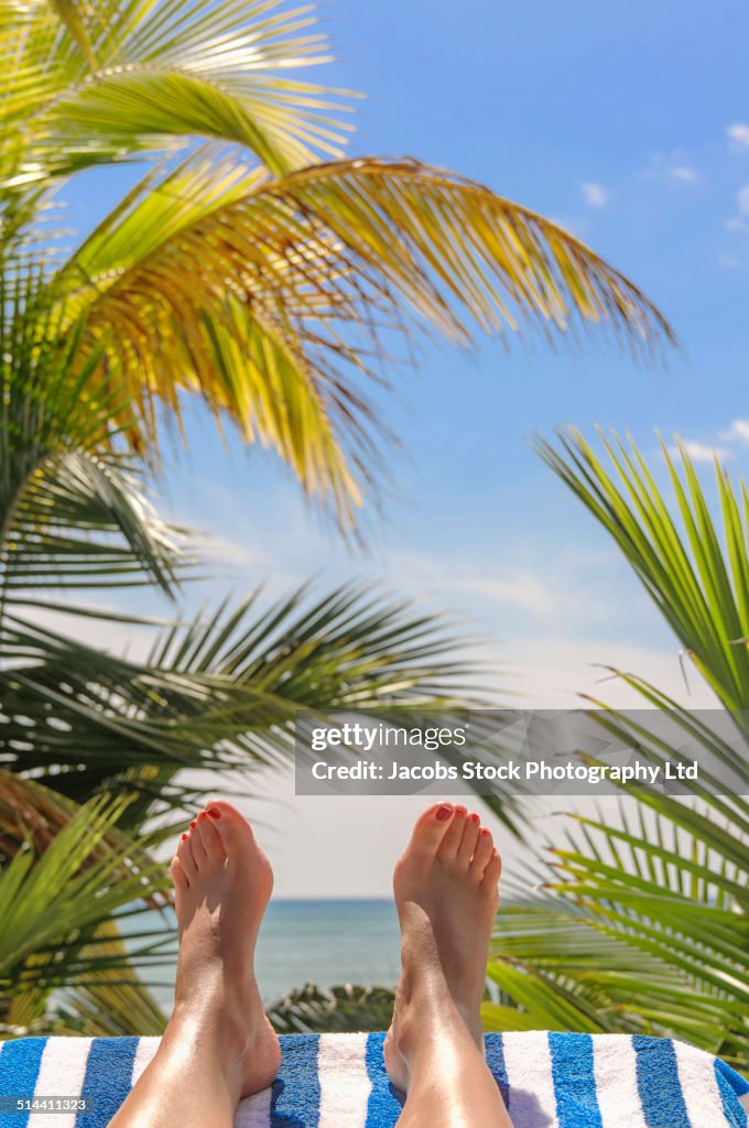 Close up of Hispanic woman's feet on tropical beach
