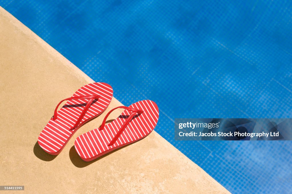 Close up of flip flops by swimming pool