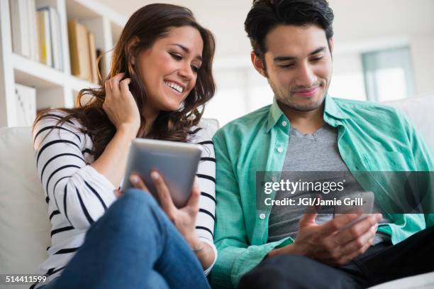 couple using technology together on sofa - mobile phone reading low angle stock-fotos und bilder