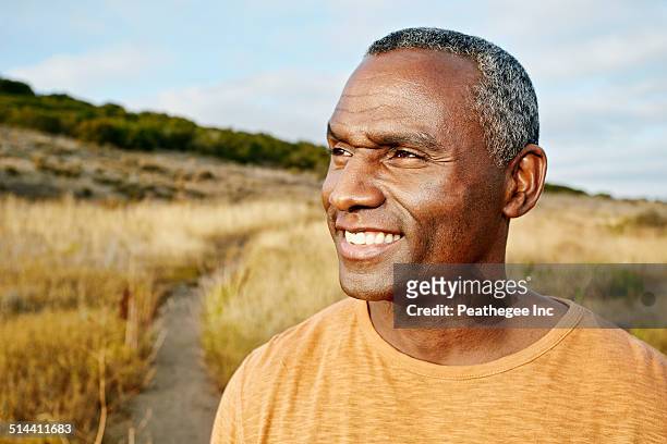 black man standing on rural path - african american hiking stock-fotos und bilder