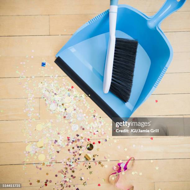 broom and dustpan with confetti on floor - dustpan and brush stockfoto's en -beelden