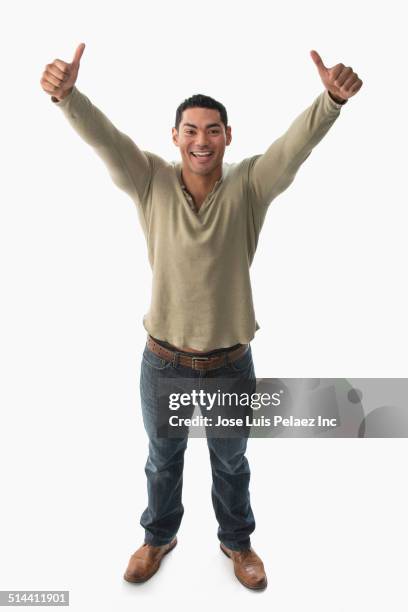 mixed race man giving thumbs-up - mixed race man standing studio stockfoto's en -beelden