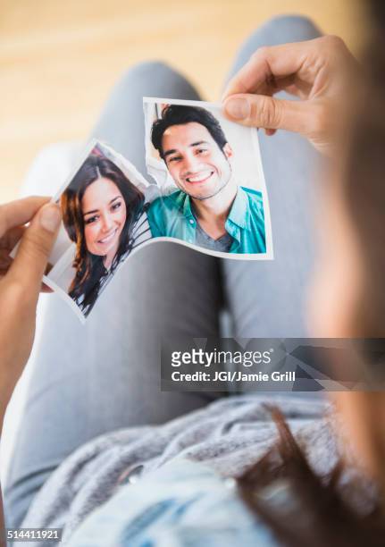 woman tearing picture of herself with ex-boyfriend - relationship difficulties photos stock pictures, royalty-free photos & images