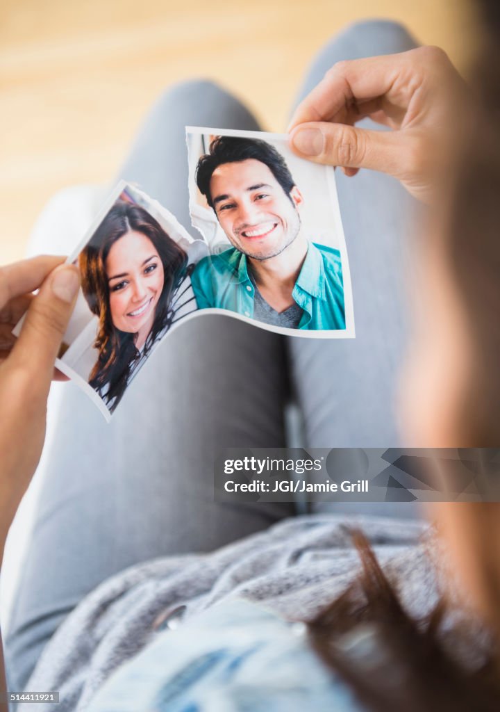 Woman tearing picture of herself with ex-boyfriend