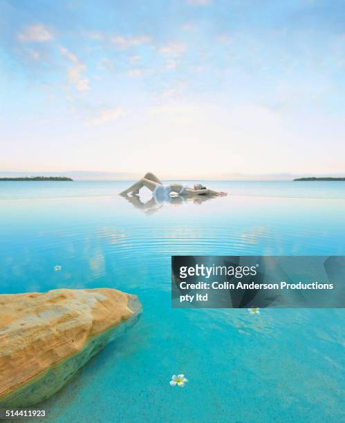 woman relaxing in still pool overlooking ocean - fiji flower stock pictures, royalty-free photos & images