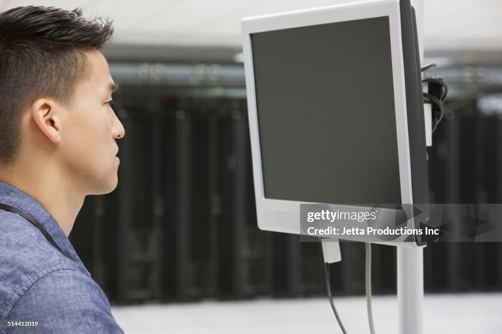 Chinese businessman using computer in server room