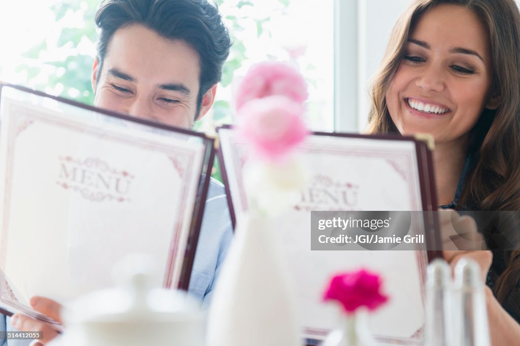 Couple reading menus in restaurant