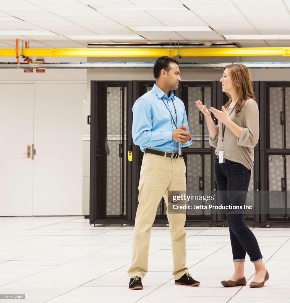 Business people talking in server room