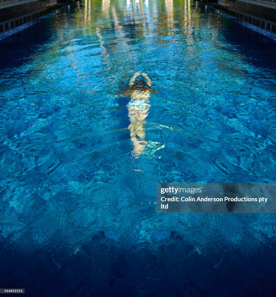 Caucasian girl swimming in pool