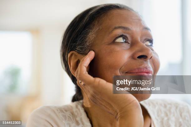 close up of mixed race woman resting chin in hand - hand on chin stock-fotos und bilder