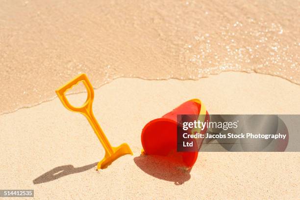 shovel and pail on sand at beach - beach shovel stockfoto's en -beelden