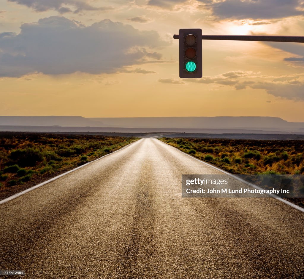 Traffic light on rural road in desert landscape