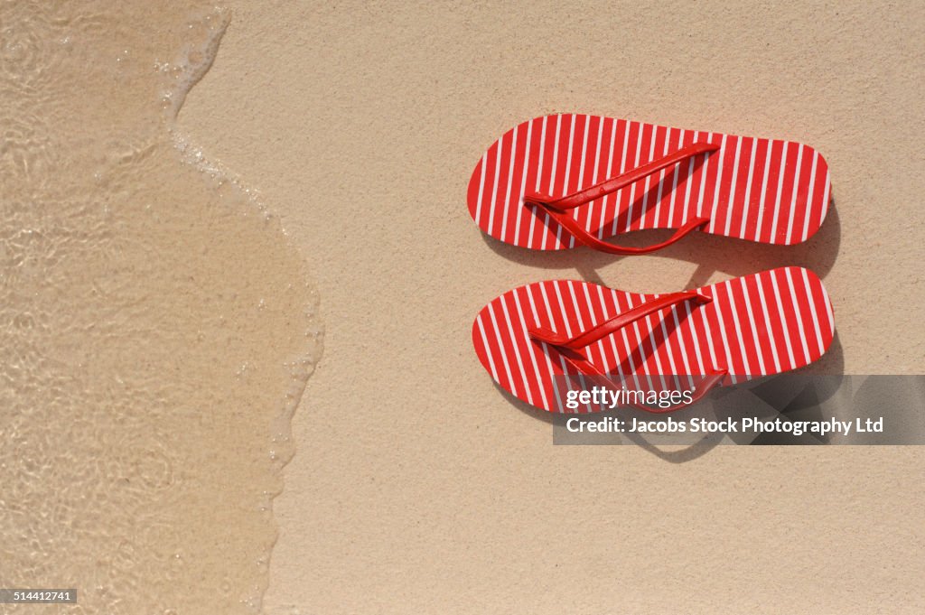 Close up of flip flops on beach